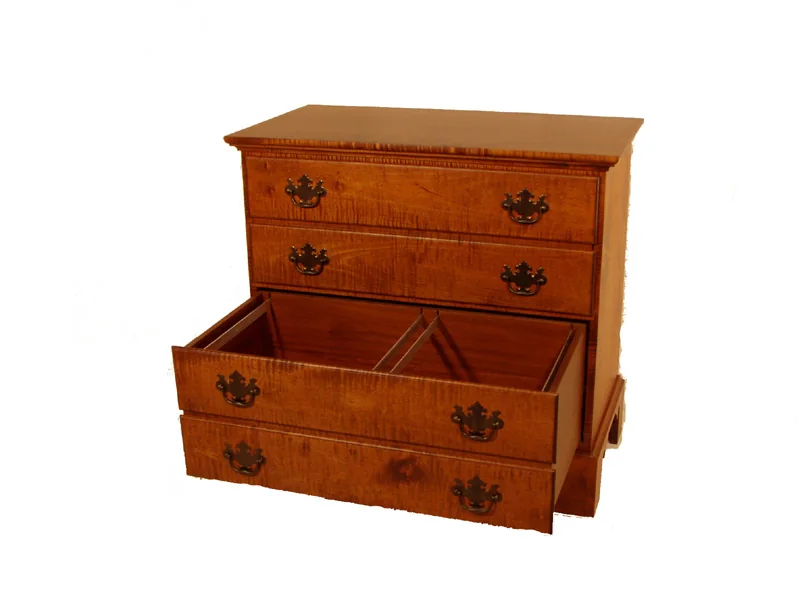 Curly maple blanket chest with the lid raised to show the till and dovetailed corners