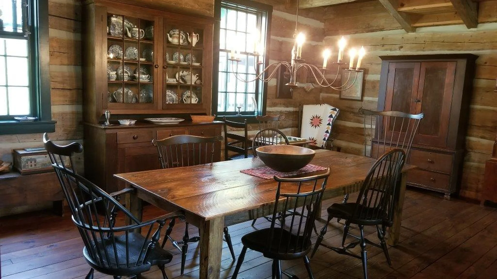 Dining room with a stretcher-base table and black Windsor chairs